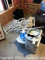 Two white metal shoe racks, white plastic three-drawer storage unit, white plastic container with compartments, hair dryers, and an Omron blood pressure monitor seen in basement area.