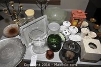 Overview of the assorted items on a table, showing the Indian cigarette dispenser, brass candelabra, fishbowl, glass and ceramic containers, and trays.