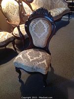 front view of chair showing carved rose crest and damask upholstery