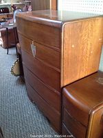 Side view of wooden highboy dresser showing five drawers and surface finish details.