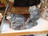 Soapstone animal carving showing side profile with leather thong detail