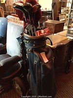 Blue golf bag with men's Spaulding right-handed golf clubs, woods and irons visible, club socks and balls visible in the bag
