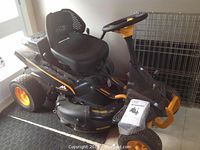 Front side view of mower showing deck, wheels, and body