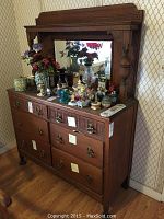 Front view of oak dresser with attached mirror and decorative items on top