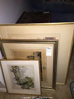 Four framed prints stacked together showing varied sizes and frame styles