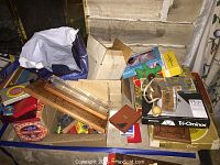 A table holding assorted boxed board games and game parts including a wooden fishing pole, games in cardboard boxes, triangular game pieces, and a puzzle box with a winter scene.