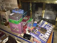 View showing stacked boxed games including Jeopardy 2002 edition, Trivial Pursuit, and other board game boxes near a fireplace hearth.