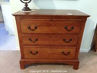 Front view of chest showing three drawers and bracket feet