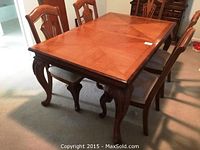 Full view of the rectangular wood dining table surrounded by chairs