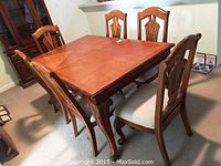 Group view of six wooden dining chairs around table