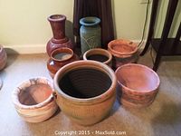 Overview of 8 assorted clay pots and heavy-duty planters with various textures and sizes.