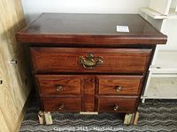 Front view of the wooden end table showing the drawers and damaged bottom drawer front.