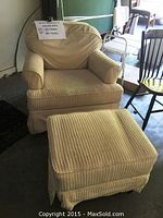 Photo showing beige corduroy rocker chair with cushioned arms and a matching ottoman with pleated skirt