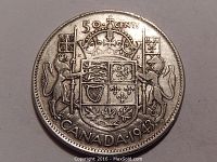 Obverse side of the 1943 Canadian 50 cent silver coin showing the coat of arms and denomination clearly.