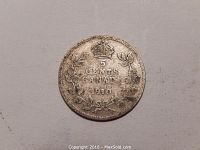 Close-up photo of the 1910 Canadian five cent silver coin with crown, maple leaves and denomination visible, showing circulated condition.