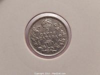 Image of the obverse side of a 1919 Canadian five cent silver coin showing denomination, country, year and decorative wreath with crown.