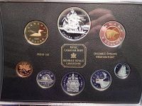 Display of all 8 proof coins from 1999 Royal Canadian Mint set with Voyage of Queen Charlotte theme, showing various denominations and coin designs including silver dollar with ship image.