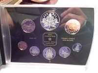 Coins displayed in black protective casing showing reflective proof quality, illustrating all nine coins with detailed Canadian designs.