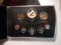 Close-up of 2009 Canadian Mint Proof Coin Set in black plastic case showing all eight coins with bomber themed designs and gold accents.