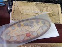 Coins arranged in oval plastic display with historical map background and multiple coins visible.