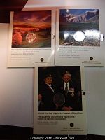 Three Royal Canadian Mint Official First Day 25-cent coins in original packaging featuring commemorative themes for Saskatchewan Centennial, Alberta Centennial, and Year of the Veteran.