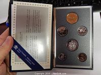 Image showing the specimen set with five 1990 Canadian coins including penny, nickel, dime, quarter, and half dollar in a black plastic case with foam insert, accompanied by certificate.