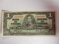 Front view of 1937 Canadian one dollar bill showing portrait of King George VI and denomination in English and French.