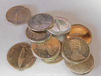 Top view of all 10 Canadian silver dimes scattered, showing both obverse and reverse sides with signs of aging and wear.