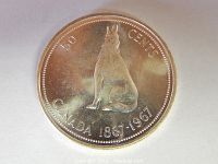 Obverse side of the 1967 Canadian 50 cent coin showing the wolf design and inscriptions.