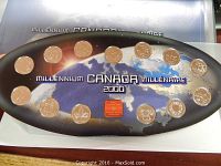 Oval coin holder with 14 Canadian coins arranged around a map with Millennium Canada 2000 text, including a small red emblem in center.
