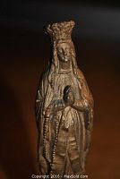 Front view of the miniature gold plated statue showing Our Lady of Notre Dame with detailed facial features, crown, and rosary in hands.