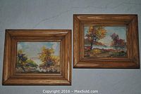 Both vintage miniature oil paintings displayed side-by-side, framed in solid oak wood showing autumn landscape scenes.