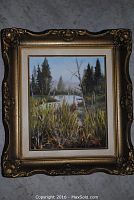 Frontal photo showing the entire framed oil painting depicting an autumn landscape with grasses, trees, and a body of water