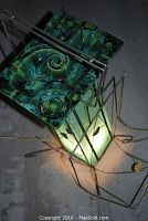 Top and angled view of glazed Beauceware ceramic ashtray showing floral and spiral patterns in green and blue glaze, sitting atop the metal magazine holder.