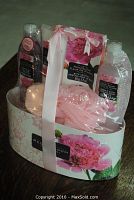 Photo of Peony Bloom bath gift set showing all included products inside pink floral container with pink ribbon.
