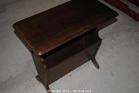 Overall angled view of the magazine side table showing single rack storage and solid wood construction.