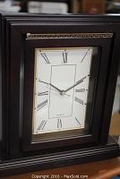 Front view of the Excelsior mantel clock showing the mahogany frame and the clock face with Roman numerals.