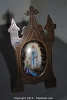 Front view of the gilt brass frame with porcelain plaque upright on easel