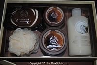 Photo showing five items in the gift set including 1 coconut soap bar, 2 jars of coconut body butter, 1 bottle of coconut shower cream, and a natural bath sponge all contained in plastic inside box.