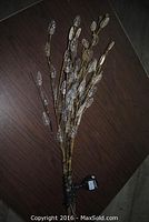 Lighted bendable branches placed flat showing brown stems and attached clear LED leaf lights with power cord and plug visible.