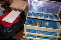 Three handbags grouped left of open jewelry box showing top tray and handbags