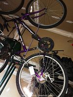 Full view of purple Roadmaster Mt Fury mountain bike leaning against a wall indoors.