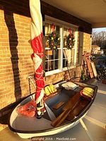 Side view of fiberglass dinghy with mast, wrapped sail, life vests onboard