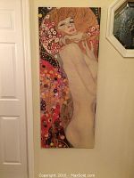 Vertical shot of Gustav Klimt Water Nymphs canvas print hanging on wall.