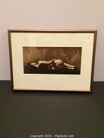 Front view of framed sepia photograph showing reclining nude figure.