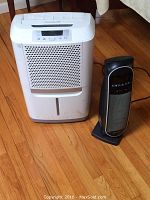 Frigidaire dehumidifier and Bionaire room heater placed on hardwood floor.