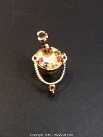 Front angled view of gold champagne bucket pendant with multi-colored semi-precious stones.