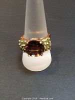 Front view showing round brown tourmaline and green tsavorite clusters on shoulders