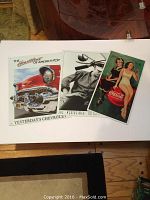 Three vintage-themed tin advertising signs with Chevrolet, Elvis, Coca-Cola logos and artwork.