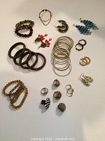 Photo showing all assorted jewelry including rings, bracelets, and earrings spread on light surface.
